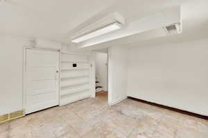 Finished basement with light flooring and baseboards