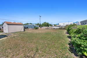 View of green lawn featuring an outbuilding