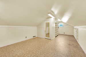 Additional living space featuring baseboards and lofted ceiling