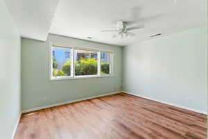 Spare room featuring wood finished floors, a ceiling fan, and a textured ceiling