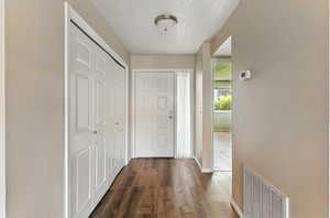 Foyer featuring dark wood-type flooring and baseboards