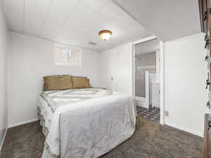 Bedroom with dark colored carpet and ensuite bath