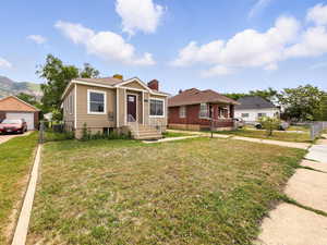 Bungalow-style home with a chimney, a detached garage, concrete driveway, and a mountain view