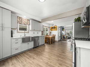 Kitchen featuring appliances with stainless steel finishes, light countertops, decorative backsplash, light wood-style floors, and recessed lighting