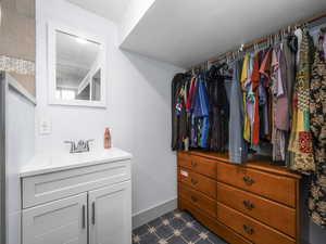 Spacious closet featuring a sink and dark flooring