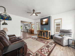 Living area with a ceiling fan and wood finished floors