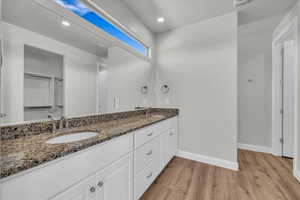 Full bathroom with wood finished floors, double vanity, and recessed lighting