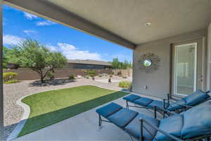 Fenced backyard featuring a patio area and an outdoor hangout area