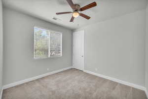 Spare room featuring ceiling fan and carpet floors