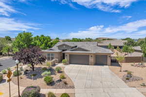 View of front facade featuring an attached garage, driveway, stucco siding, and a tiled roof