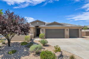 View of front of property featuring stucco siding, driveway, a garage, and stone siding