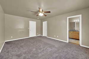 Unfurnished bedroom with carpet flooring, connected bathroom, and a ceiling fan
