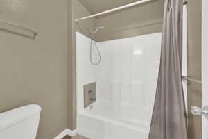 Bathroom with shower / tub combo with curtain and baseboards