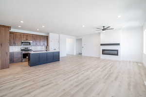 Kitchen featuring stainless steel appliances, recessed lighting, a ceiling fan, decorative backsplash, and open floor plan