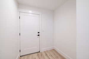 Doorway to outside featuring light wood-style flooring and baseboards