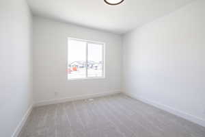 Unfurnished room featuring light colored carpet and baseboards