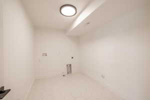Washroom with gas dryer hookup, hookup for an electric dryer, washer hookup, and light tile patterned flooring