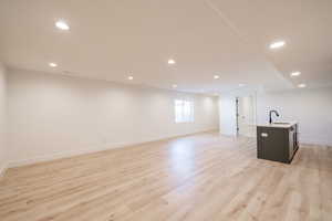 Below grade area featuring light wood finished floors and recessed lighting