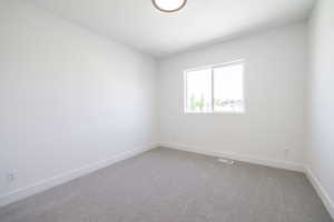Empty room with carpet floors and baseboards