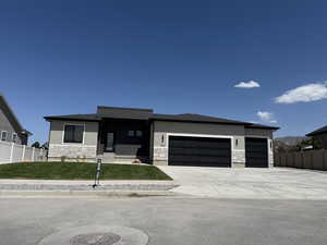 Prairie-style house with stone siding, a garage, driveway, a porch, and stucco siding
