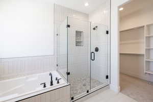 Full bathroom with a stall shower, a garden tub, a walk in closet, recessed lighting, and tile patterned flooring