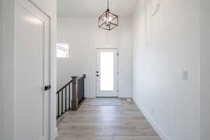 Foyer entrance featuring a chandelier and light wood-style flooring