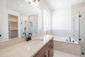 Full bath featuring vanity, a shower stall, a bath, and tile patterned flooring