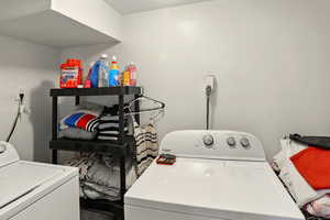 Laundry room with separate washer and dryer and wood finished floors