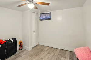 Living area featuring light wood-style floors, ceiling fan, and a textured ceiling