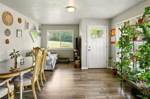 Foyer entrance with wood finished floors and a textured ceiling