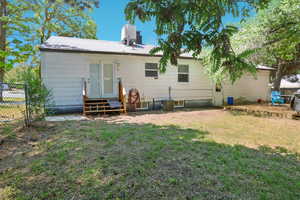 Back of house with entry steps, a wooden deck, and a chimney