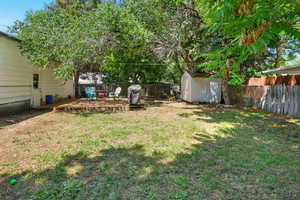 Fenced backyard featuring a shed