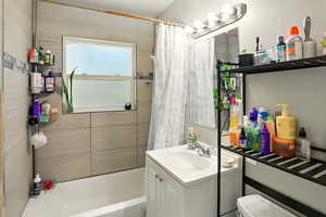 Bathroom featuring vanity and shower / bath combo with shower curtain