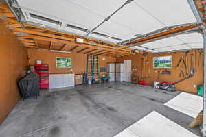Detached two car garage with attic space for extra storage, two windows for plenty of light, cabinet workbench with overhead lighting, man door to backyard, two light on the corner by the man door and two storage pantries