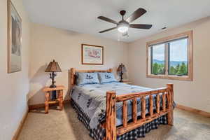 Carpeted bedroom with baseboards and a ceiling fan
