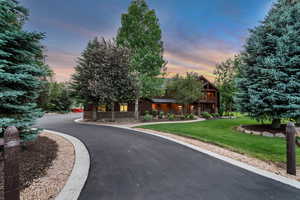 View of front of house featuring a lawn, driveway, and stone siding