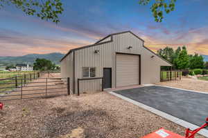 Outdoor structure at dusk featuring driveway and a mountain view