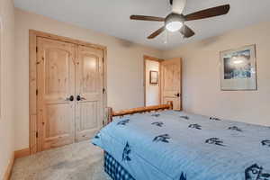 Carpeted bedroom featuring a ceiling fan