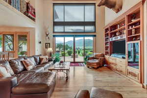 Living area featuring a high ceiling and hardwood / wood-style floors