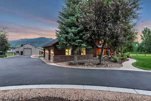 View of front of property with stone siding, a mountain view, an outbuilding, and a garage