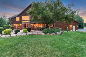 Back of property featuring a lawn and a patio