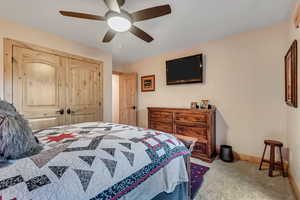 Bedroom featuring carpet, ceiling fan, and a closet