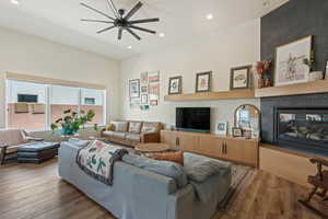 Living room with wood finished floors, ceiling fan, recessed lighting, and a multi sided fireplace