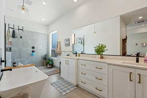 Full bath with vanity, a soaking tub, a tile shower, recessed lighting, and tile patterned floors