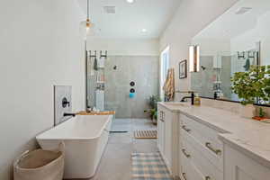 Full bathroom featuring walk in shower, vanity, a freestanding tub, and recessed lighting