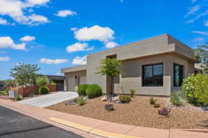 View of front of house with a garage, stucco siding, and driveway