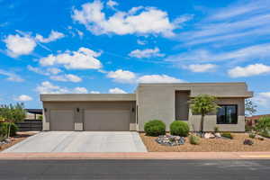Southwest-style home with an attached garage, concrete driveway, and stucco siding