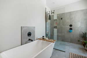 Full bathroom featuring a soaking tub and a walk in shower