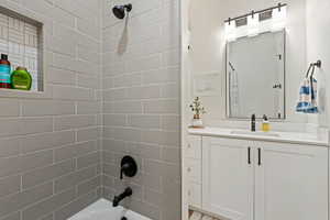 Bathroom with vanity and shower / washtub combination