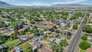 Aerial view of property and surrounding area featuring mountains and nearby suburban area